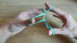 “Crazy Man’s Handcuffs”: Rubberband through rubberband trick